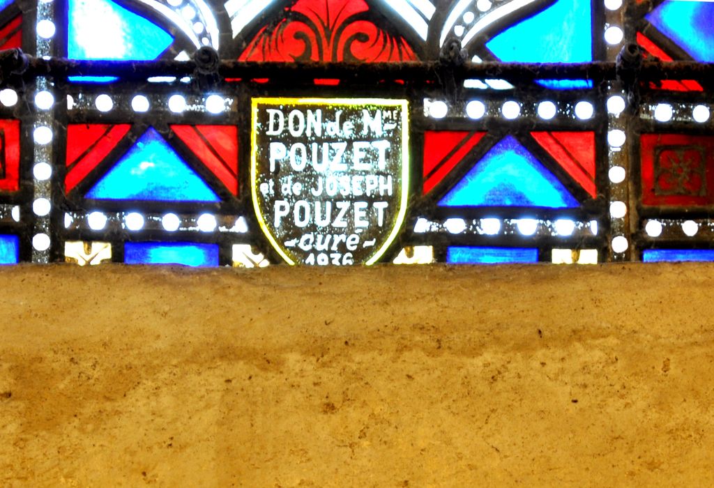 Abside : vitrail, détail de l'inscription : DON DE Mme POUZET ET DE JOSEPH POUZET CURE, 1936.