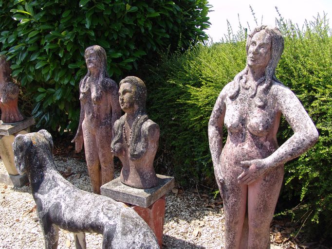 Statues et buste de femmes nues situés à l'arrière du jardin.