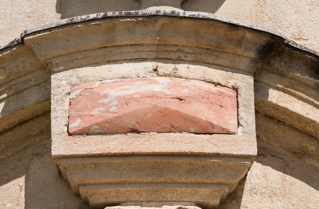 Façade sud, tourelle ouest, détail de la porte : pierre polychrome en cabochon.