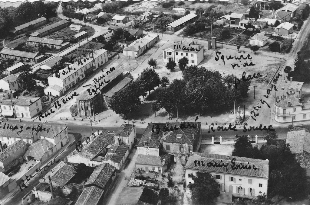 Carte postale (collection particulière) : vue aérienne du village, baraquements construits sur la place, rue du 19 mars 1962 et rue Jules-Ferry (2e moitié 20e siècle)