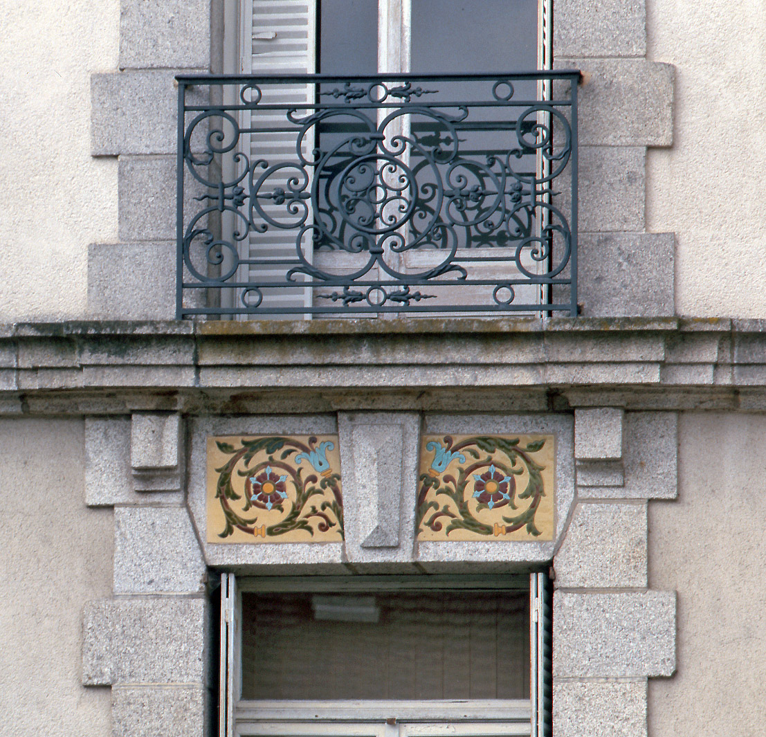 Détail des linteaux surmontant les baies, avec leur décor de céramique moulée polychrome à motifs floraux. 