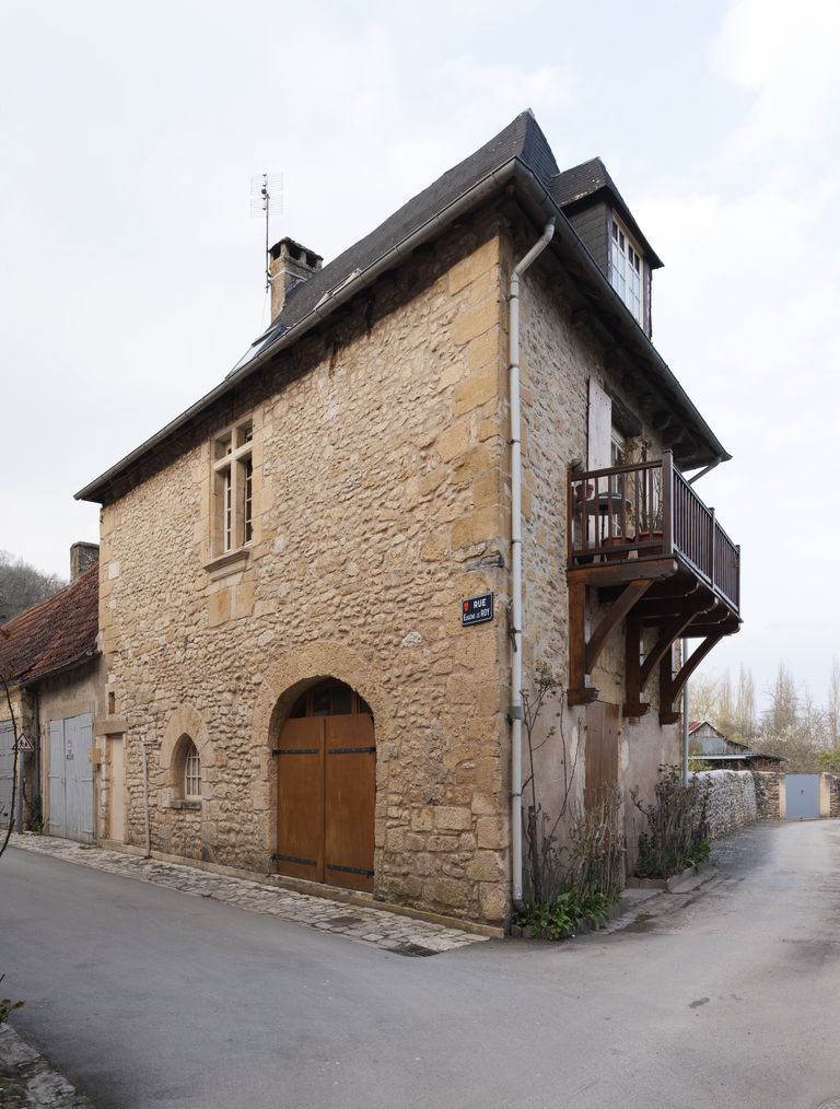 Maison du XIVe siècle de Montignac ; élévation (ouest) sur la rue Eugène Le Roy présentant les vestiges d'une porte en arc brisé à longs claveaux au rez-de-chaussée et une fenêtre (une croisée) du XVIe siècle à l'étage.