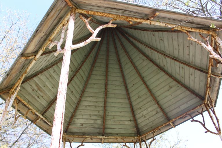 Kiosque : détail de la toiture en bois portée par la structure métallique.