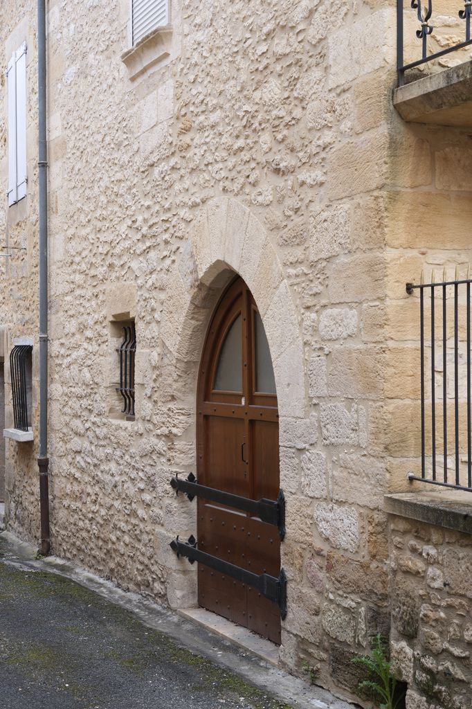 Maison du XIVe ou du XVe siècle de Montignac : détail de la porte en arc brisé à longs claveaux, d'une fenêtre d'origine agrandie et d'un appui mouluré (premier étage).