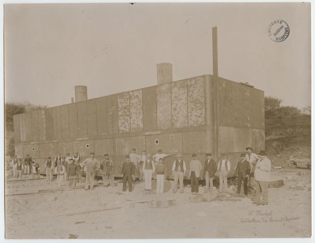 Chantier de construction de la jetée-débarcadère en 1896 : les ouvriers et, à droite, M. Michel, conducteur des Ponts et chaussées, devant le caisson étanche.