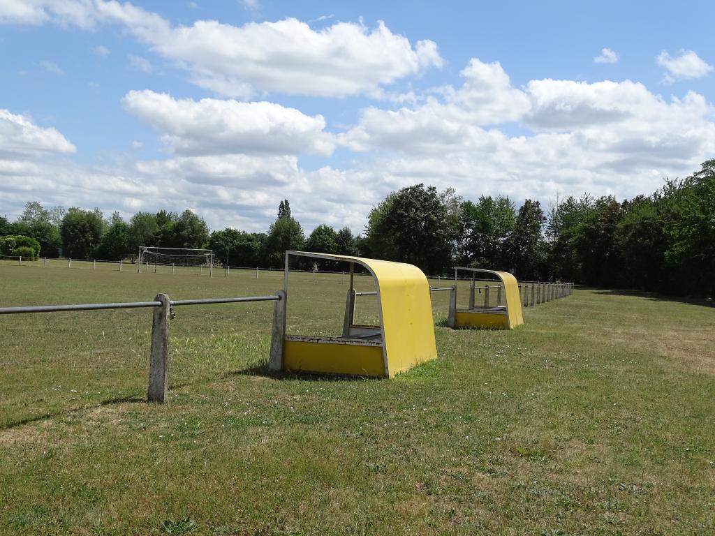 Deux bancs de touche en bordure du terrain de football.