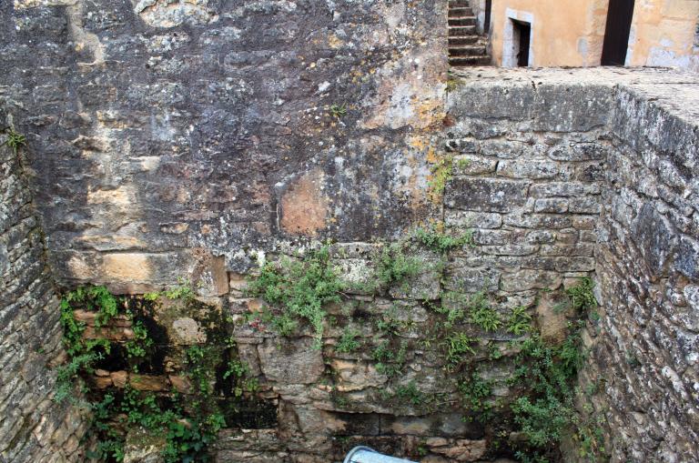 Détail au nord du mur de soutènement de la grande terrasse du château : ancienne porte à cadre à chanfrein droit murée en place dans la maçonnerie.