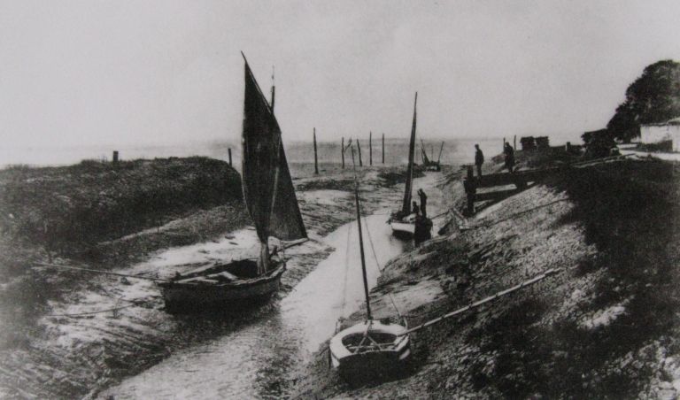 Le port à marée basse sur une carte postale vers 1930.