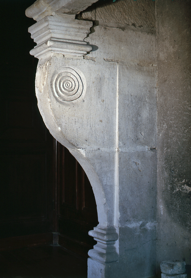 Détail du piédroit de la cheminée monumentale orné d'un décor sculpté de volute rentrante.
