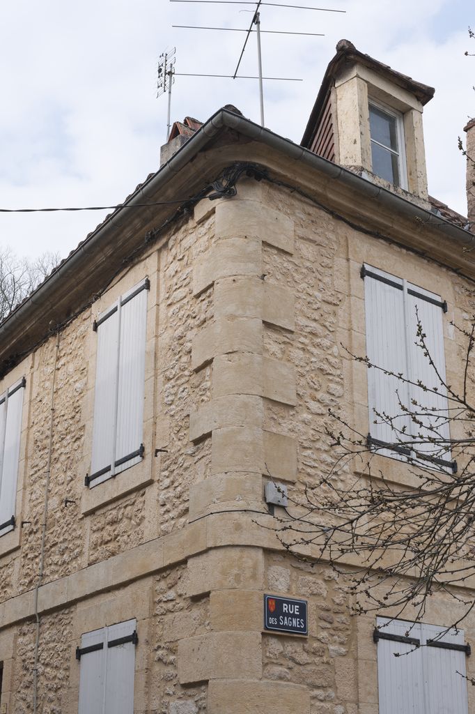 Maison du XIXe siècle de Montignac : détail de l'angle adouci des deux façades avec cordons et corniches continus.