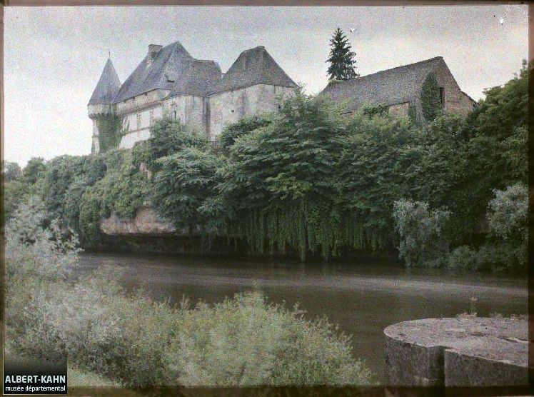 Le château de Losse vu au nord-est depuis la rive gauche de la Vézère, l'écluse de Losse au premier plan à droite, photographie autochrome, 13 juin 1916 (Musée départemental Albert-Kahn, A008884).