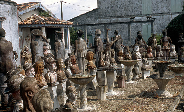 Vue d'ensemble des statues et bustes situés devant la maison.