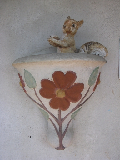 Statue d'écureuil, probablement offerte par Franck Vriet, posée sur un support fixé à la façade de la maison.