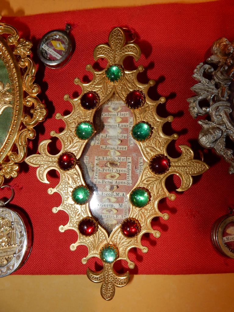 Détail d'une boîte de reliquaire contenant plusieurs reliques, décorée de cabochons.