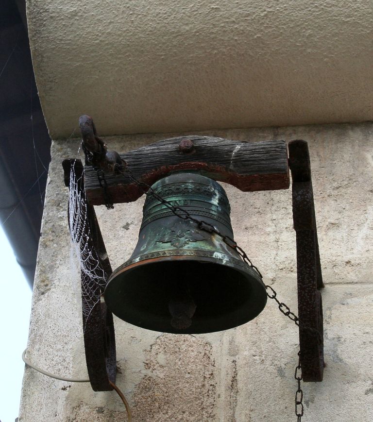 Cloche fixée sur la façade du logis.
