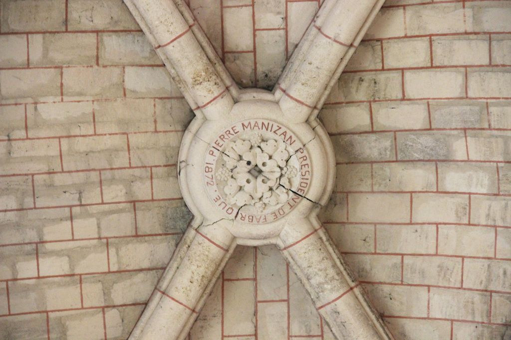 Bras de transept nord, clé de voûte sculptée : Pierre Manizan président de fabrique 1872.