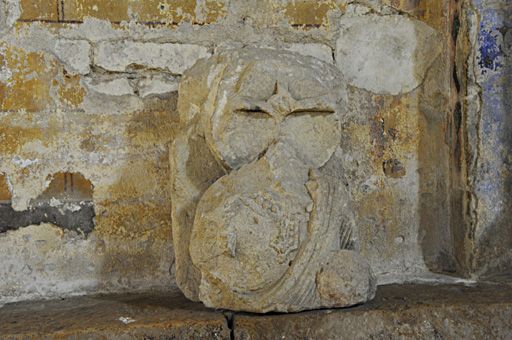 Statue déposée dans la deuxième travée du collatéral sud, vue de face : personnage portant un nimbe orné d'une croix, Christ (?).