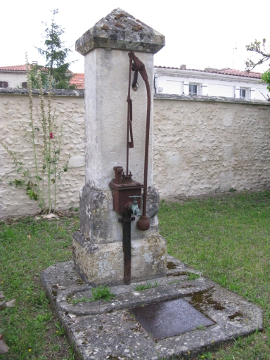 La pompe du puits devant la maison.