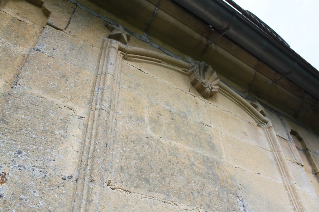 Trumeau du côté nord du bâtiment principal : détail d'une grande table à cadre mouluré et décor d'étoiles et de coquille.