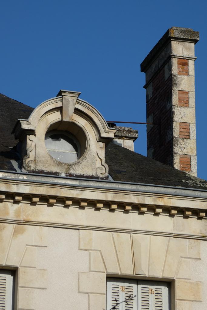 Souche de cheminée et lucarne ronde.
