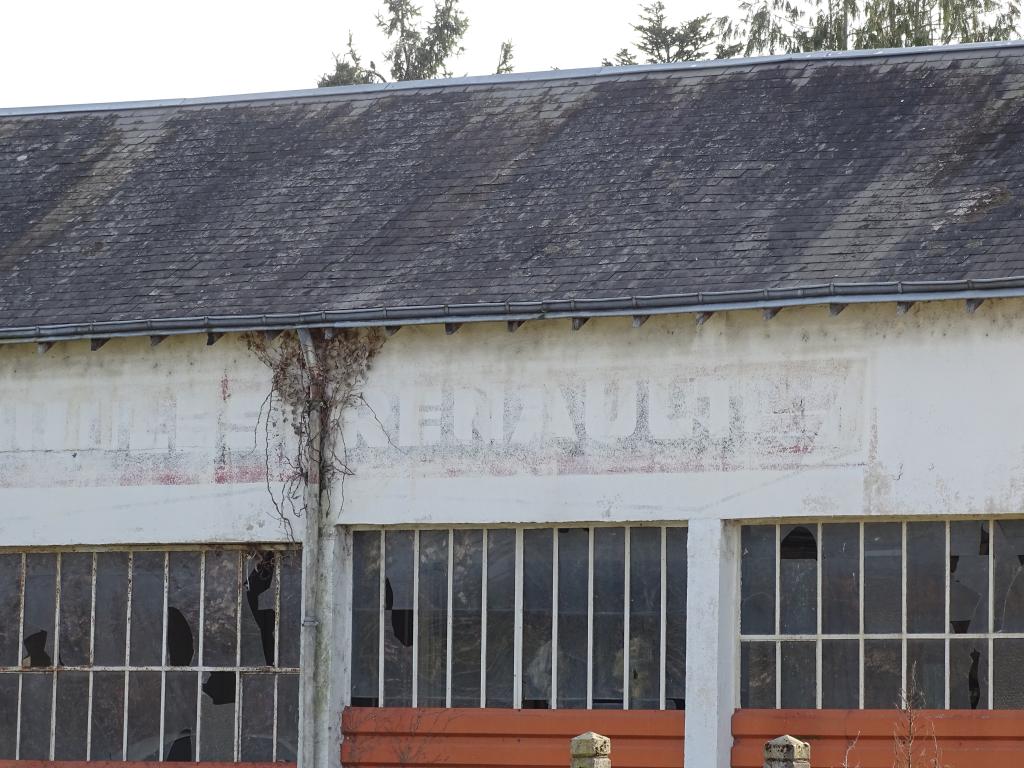 Maison et ancien garage : enseigne peinte pour les huiles Renault.