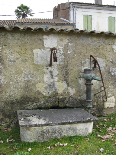 Le puits contre le mur le long de la rue du Port.