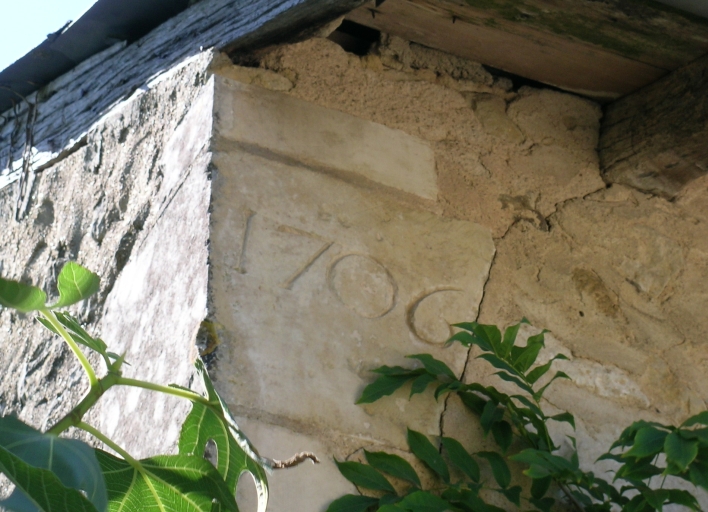 La date 1706 remployée dans un angle de la petite grange de l'ancienne métairie.