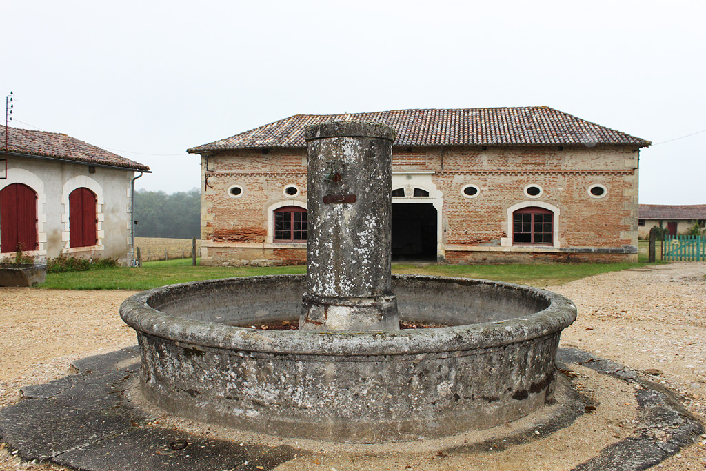 Fontaine située au centre de la cour de ferme.