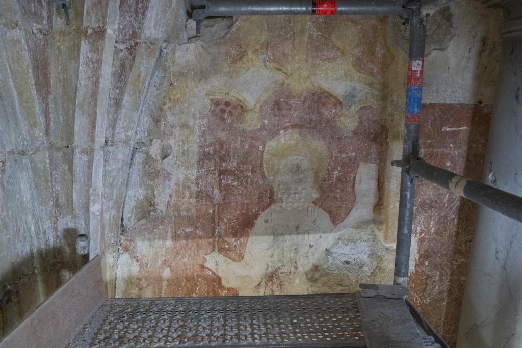 Détail d’un saint auréolé ou du Christ inscrit sous une arcature gothique.