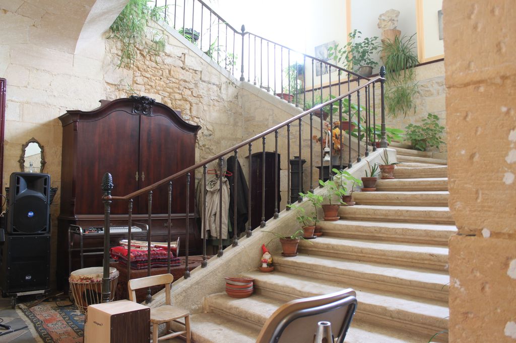 Vue du départ de l'escalier principal, avec sa rampe en fer du XIXe siècle.