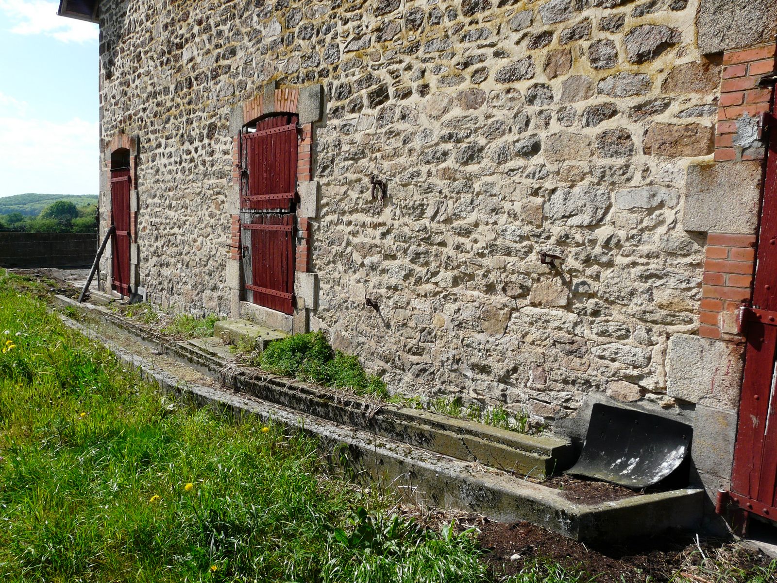 La rigole de l'étable se poursuit à l'extérieur, sur le pignon nord-est de la grange-étable.