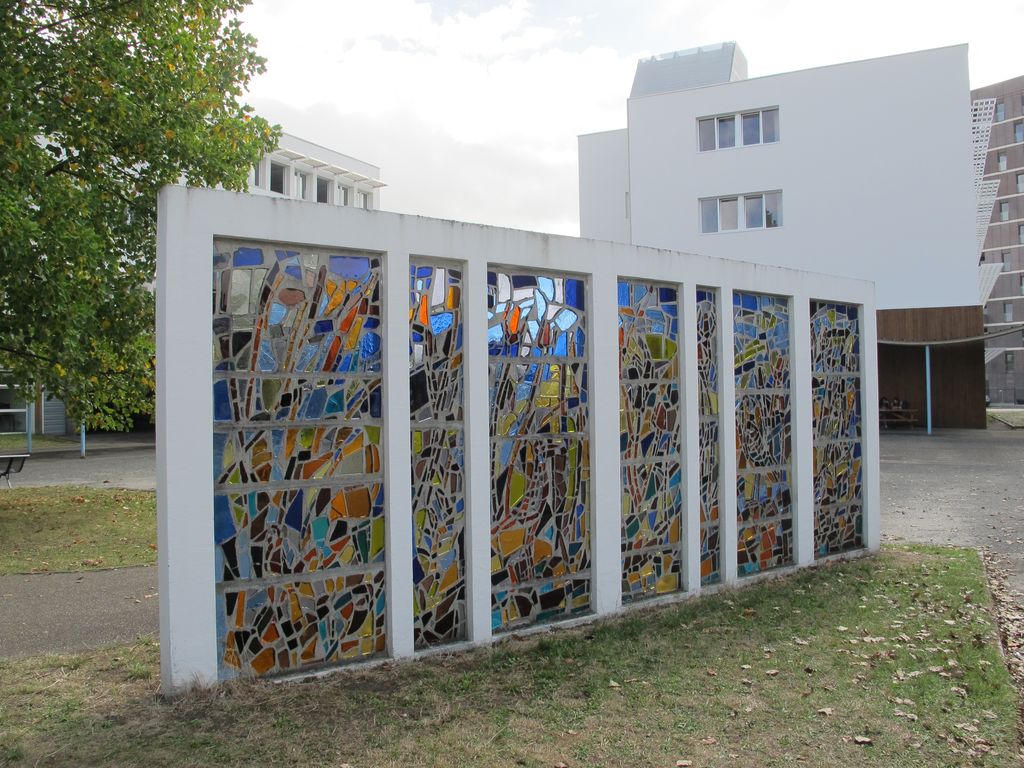 Ancien mur de dalles de verre du bâtiment d'entrée du lycée (déposé dans la cour).